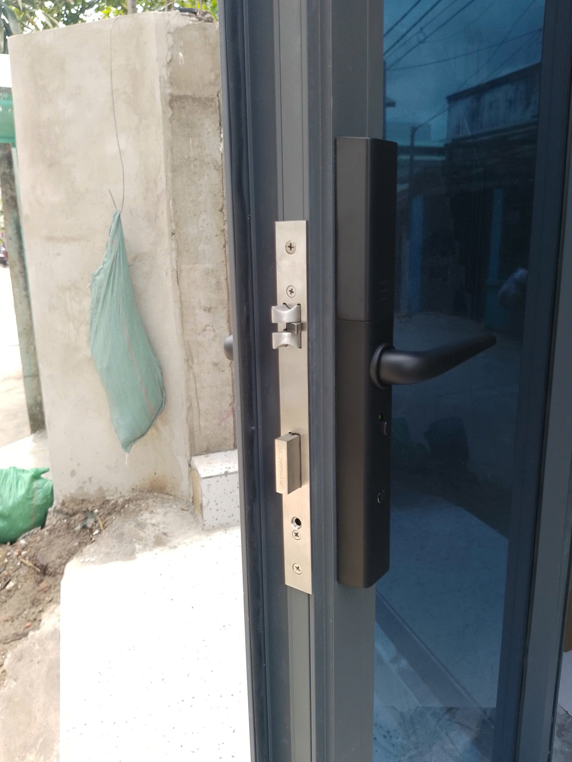 Góc nghiêng khóa vân tay Avolock AN-395-B: thanh khóa inox bắt thẳng hàng, khắc rõ AVOLOCK — ảnh lắp đặt thực tế