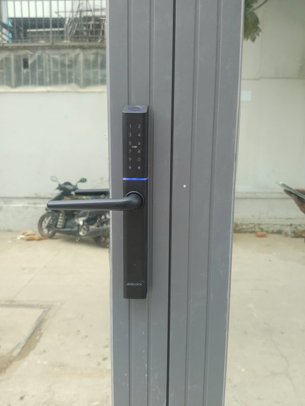 Mặt trước khóa vân tay Avolock AN-395-B lắp đặt thực tế trên cửa nhôm kính: bàn phím cảm ứng sáng đèn, cảm biến vân tay viền LED xanh