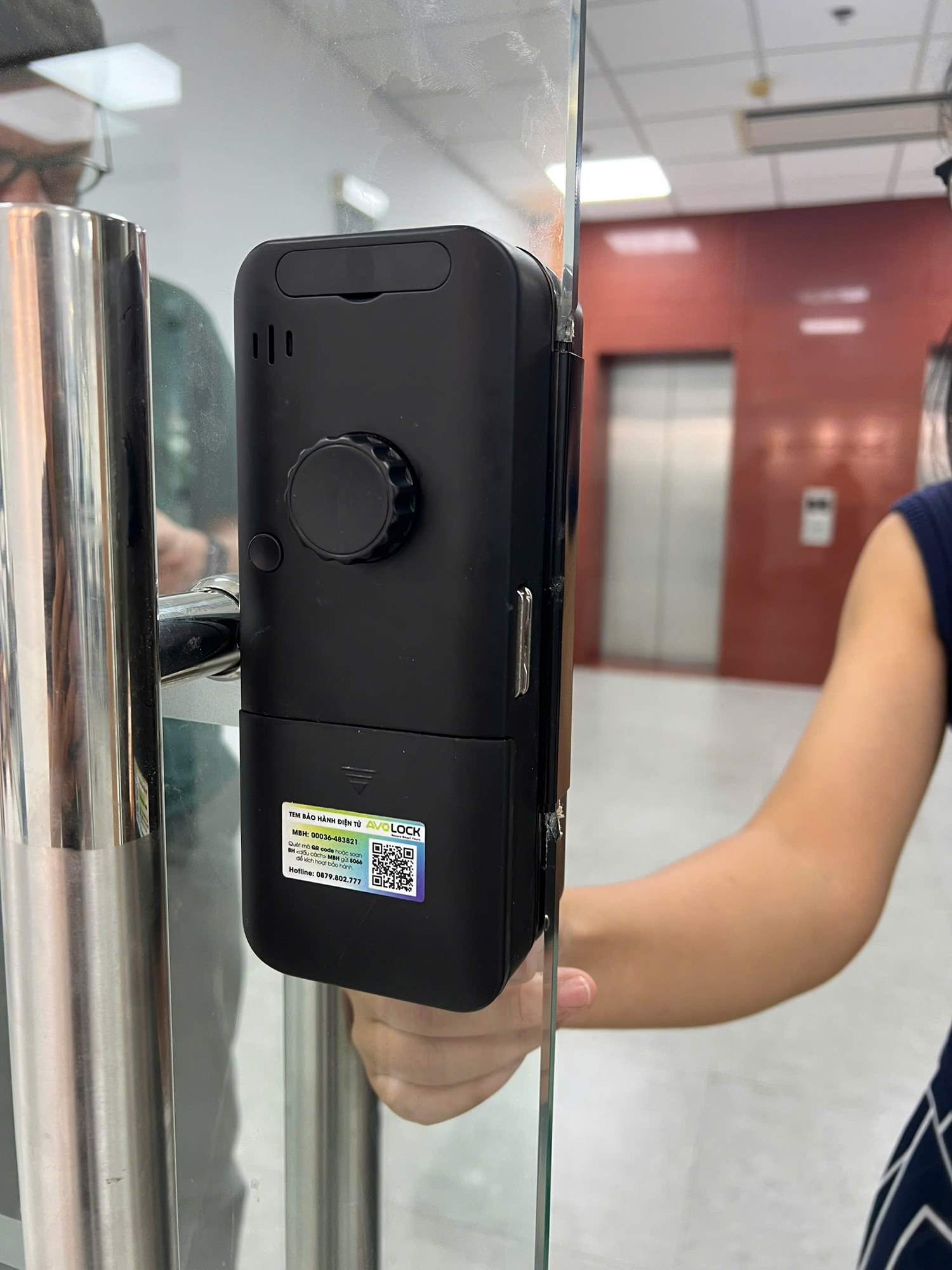 Mặt trong khóa cửa kính Avolock AK28 với núm xoay mở cửa và tem bảo hành điện tử