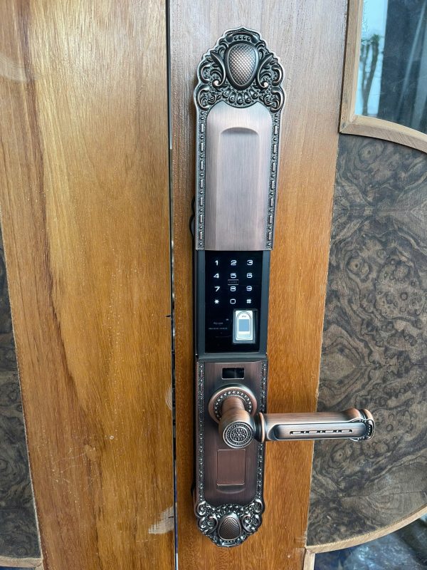 Khóa vân tay tân cổ điển Avolock AC 994 lắp đặt thực tế trên cửa gỗ biệt thự — mặt ngoài với nắp trượt, bàn phím cảm ứng và đầu đọc vân tay