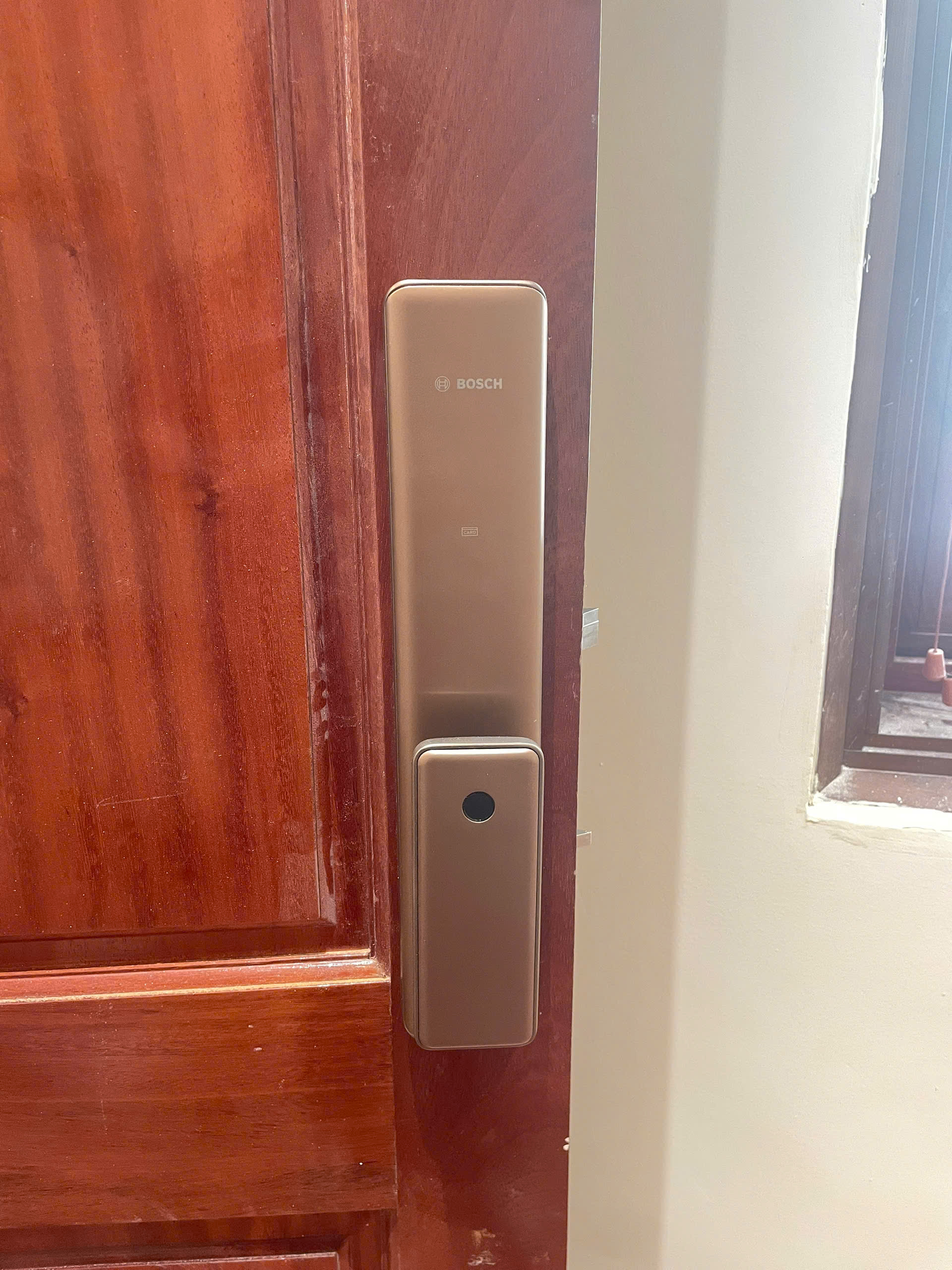 Mặt trước khóa vân tay Bosch FU750-Gold push-pull màu vàng đồng lắp đặt thực tế trên cửa gỗ